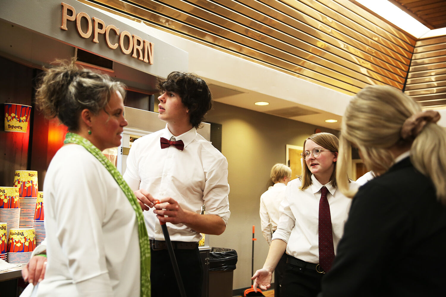 Theater co-owner Kira Wages, right, talks with the high school students